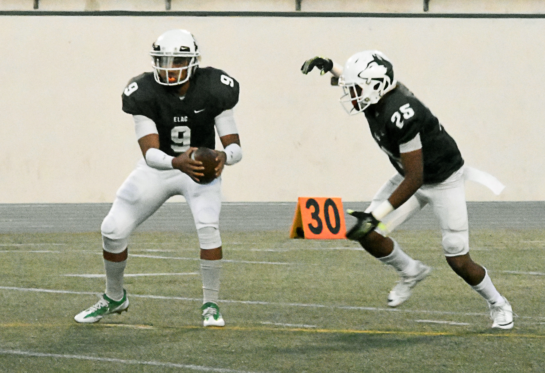 East Los Angeles College sophomore quarterback Jonathan Santos hands off to freshman wide receiver Aubrey Mosley-Laughlin who rushes for 3 yards to the ELAC 48 yard line in a 63-17 Husky win against Pasadena City on Nov. 5. (Photo by DeeDee Jackson)