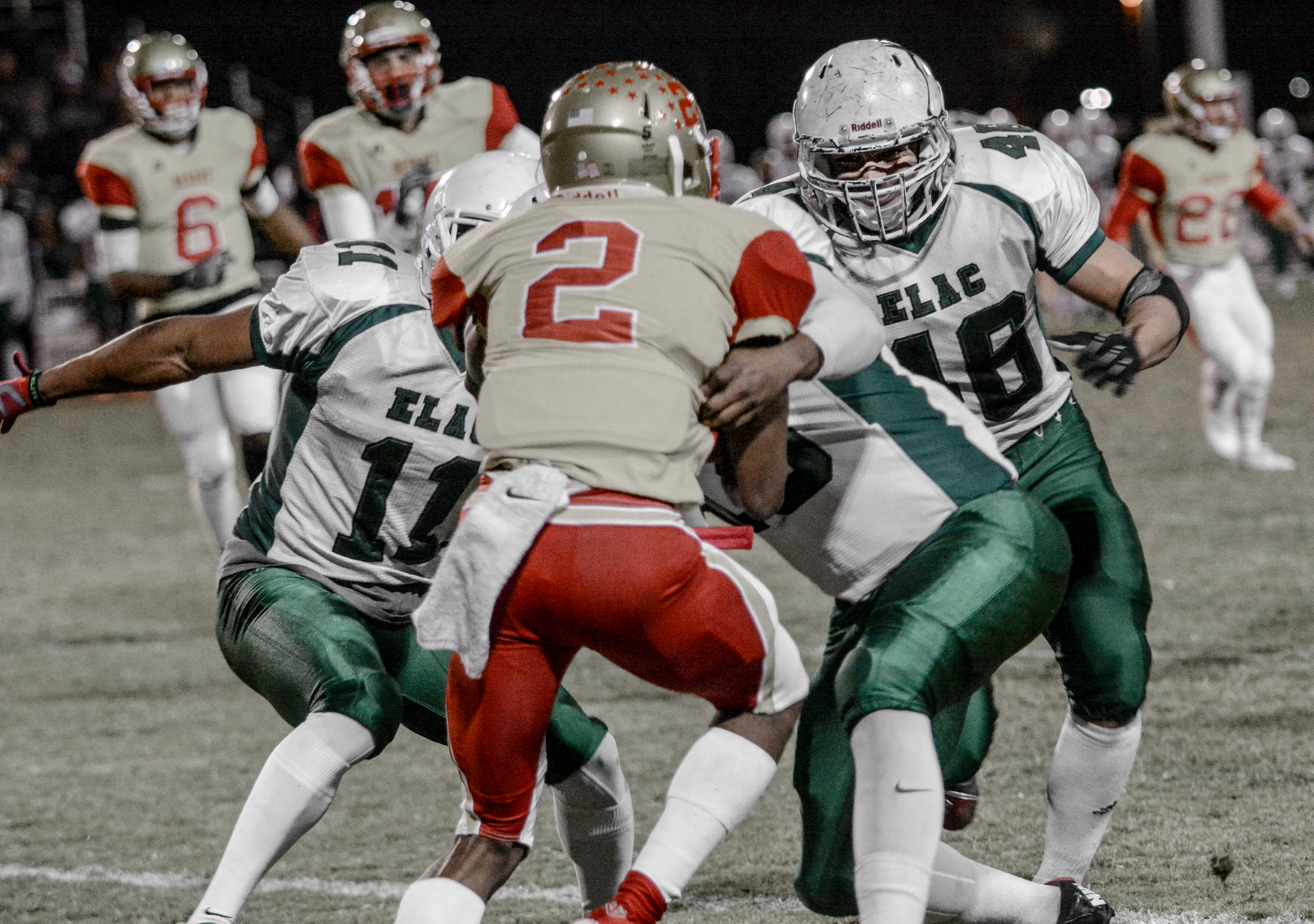 ELAC sophomores, corner back Cinwon Whitehead (No. 11) and linebacker Anthony Perez, attempt to assist in a tackle of the Desert quarterback in a 63-37 Patriotic Bowl win. (Photo by Tadzio Garcia)