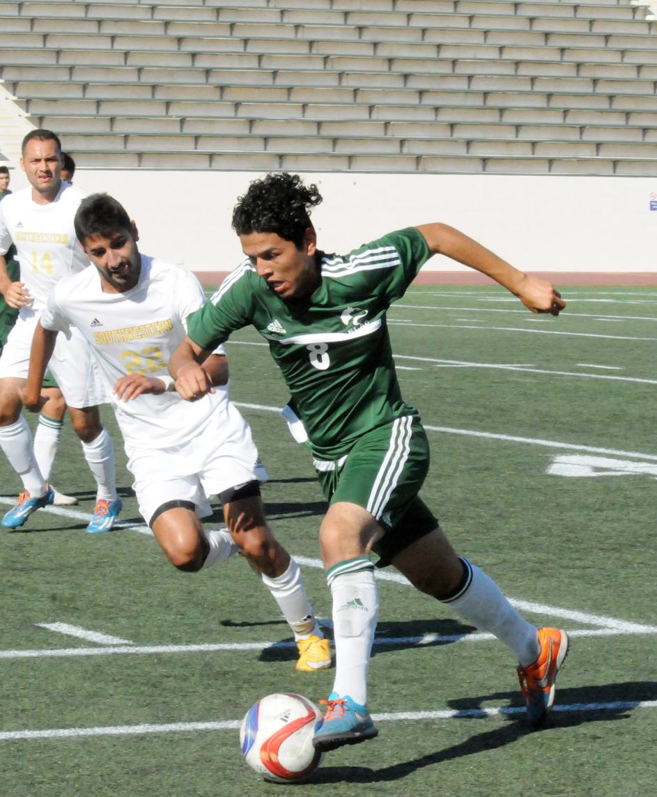 East Los Angeles College freshman midfielder Hugo Flores (No. 8) moves the ball near midfield running by Southwestern College sophomore midfielder Adrian Ramos in a 1-1 draw against the Jaguars on August 28 at Weingart Stadium. (Photo by DeeDee Jackson)