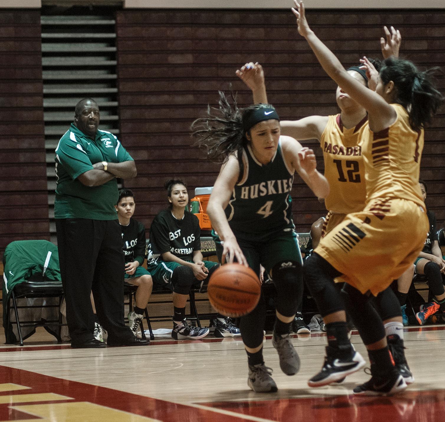 East Los Angeles College freshman guard Allissa Gomez drives near the baseline around two Pasadena City College defenders in a 51-47 Husky win against the Lancers Jan. 28, 2015. (Photo by Tadzio Garcia, Photojournalist)