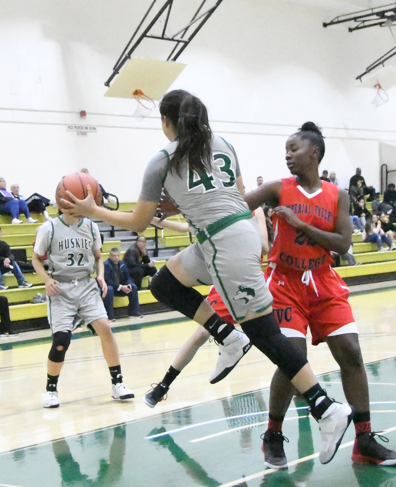 East Los Angeles College freshman guard Monica Garcia jumps up and around Imperial Valley forward Carmelita Smith in a 99-19 win on Dec. 27. (Photo by DeeDee Jackson)