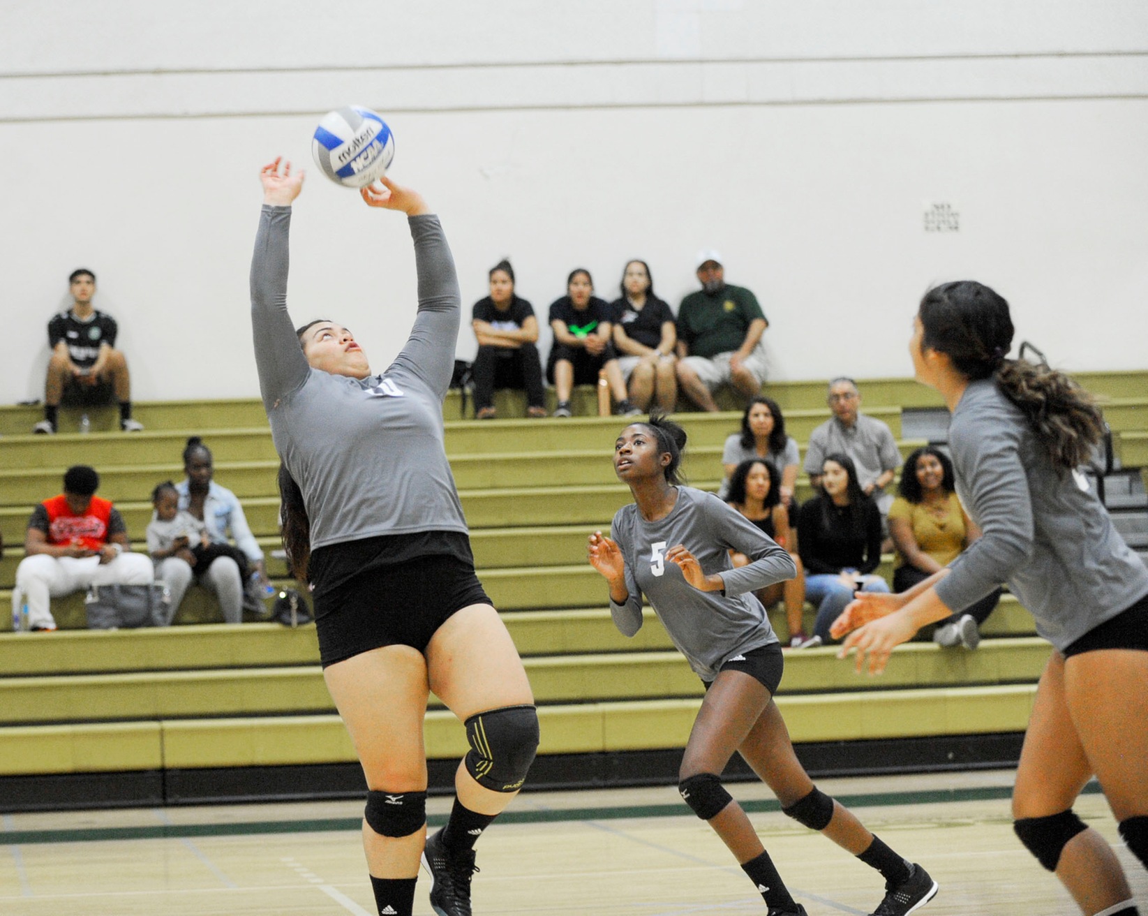 East Los Angeles College freshman setter Aifili Tuita'u sets the ball behind her so freshman middle hitter Daija Walton (No. 5) can attempt a kill in the second set of a 3-0 win vs. LA Harbor. (Photo by Tadzio Garcia)