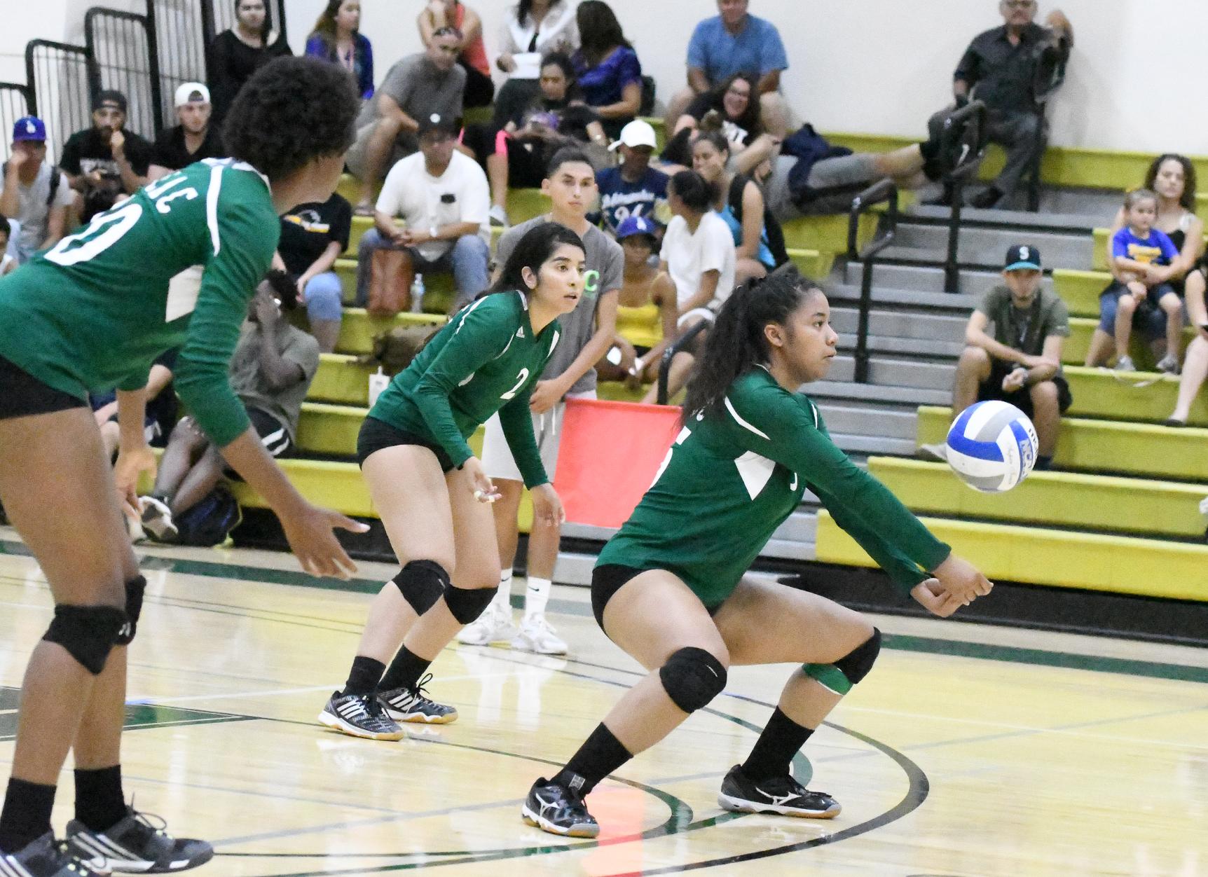 East Los Angeles College sophomore outside hitter Angela Wade gets low and digs the ball as Huskies (from left) look on, freshman Esther Duru and sophomore Sophia Leon. (Photo by DeeDee Jackson)